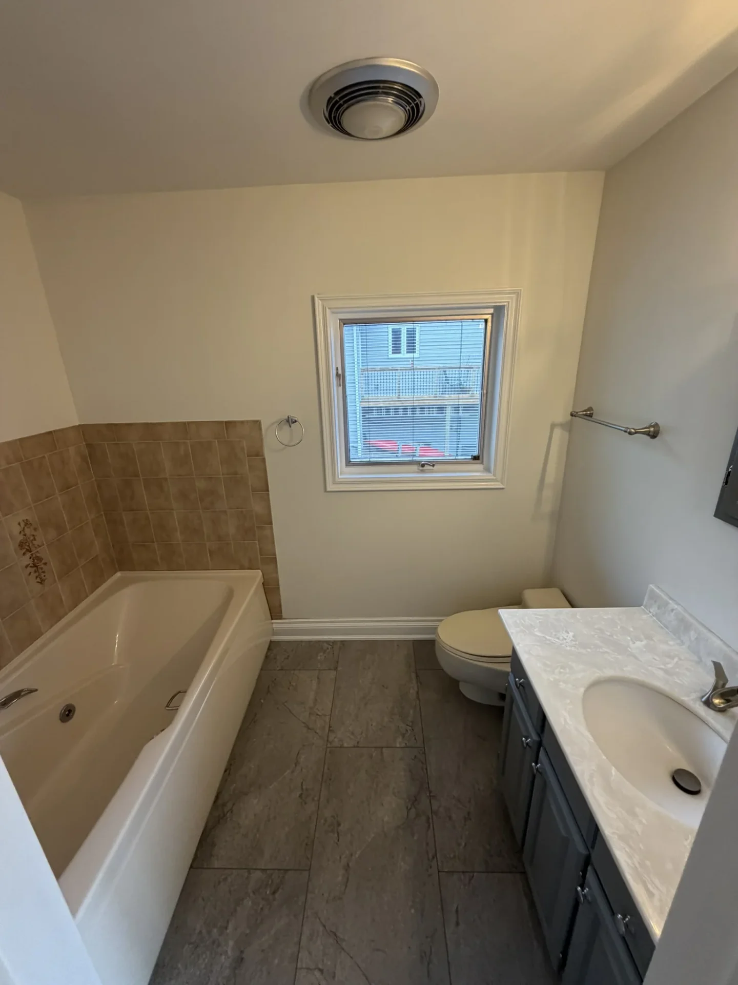 Master bathroom with deep soaker tub, tile surround, and natural light