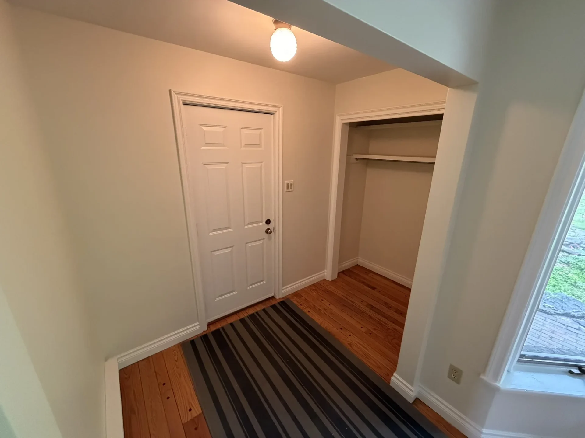Bright secondary entryway from attached garage with hardwood floors