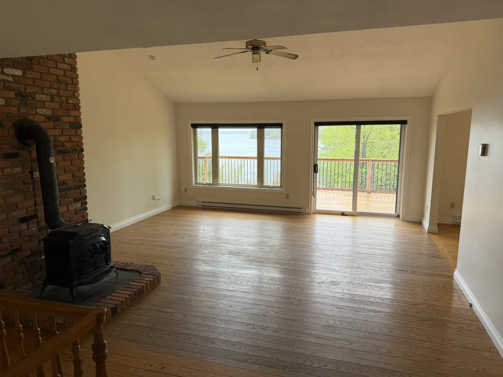 Living room with wood stove and sliding doors out to the lakeside deck