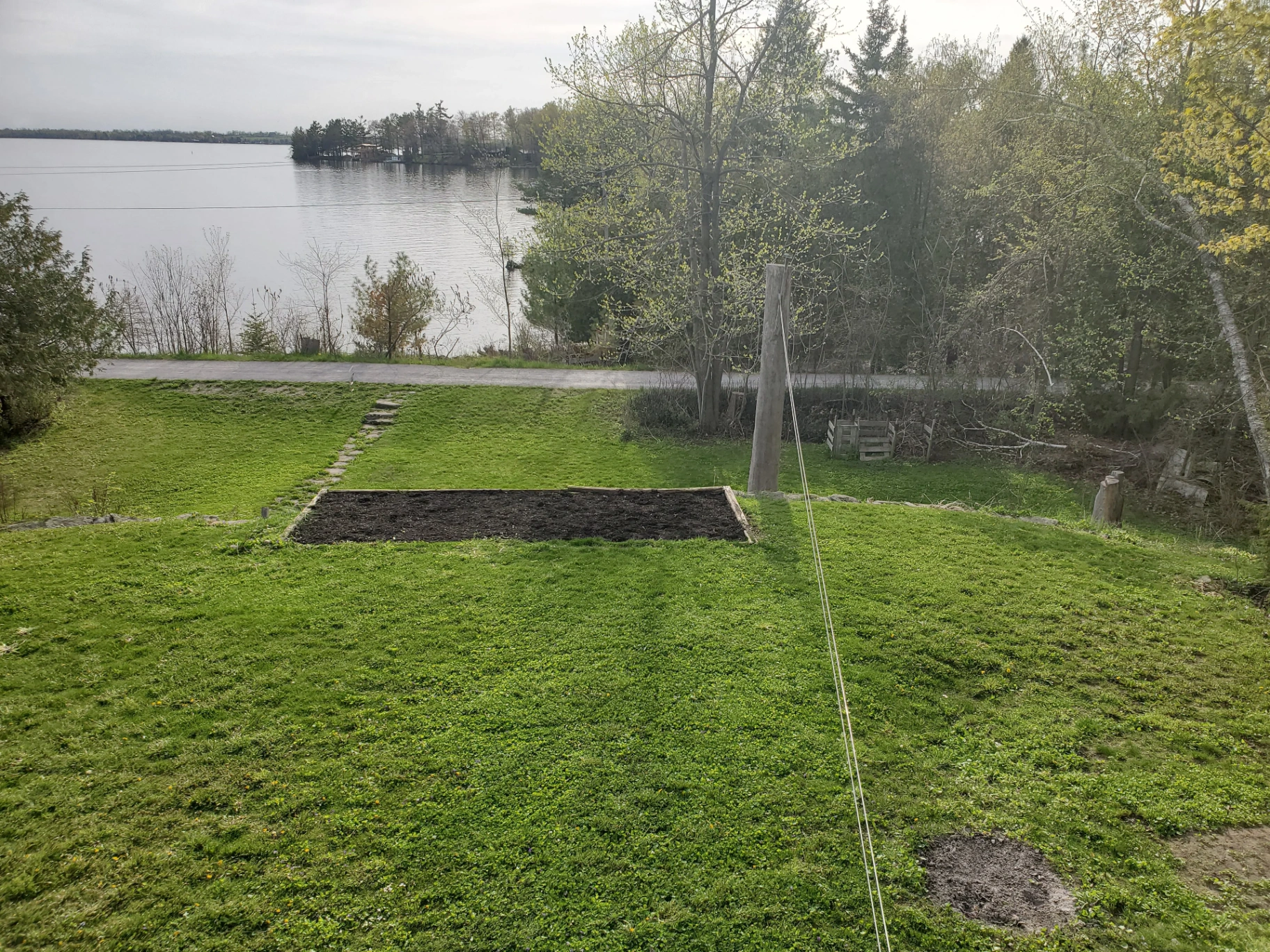 Backyard sloping down to the lake with raised garden bed